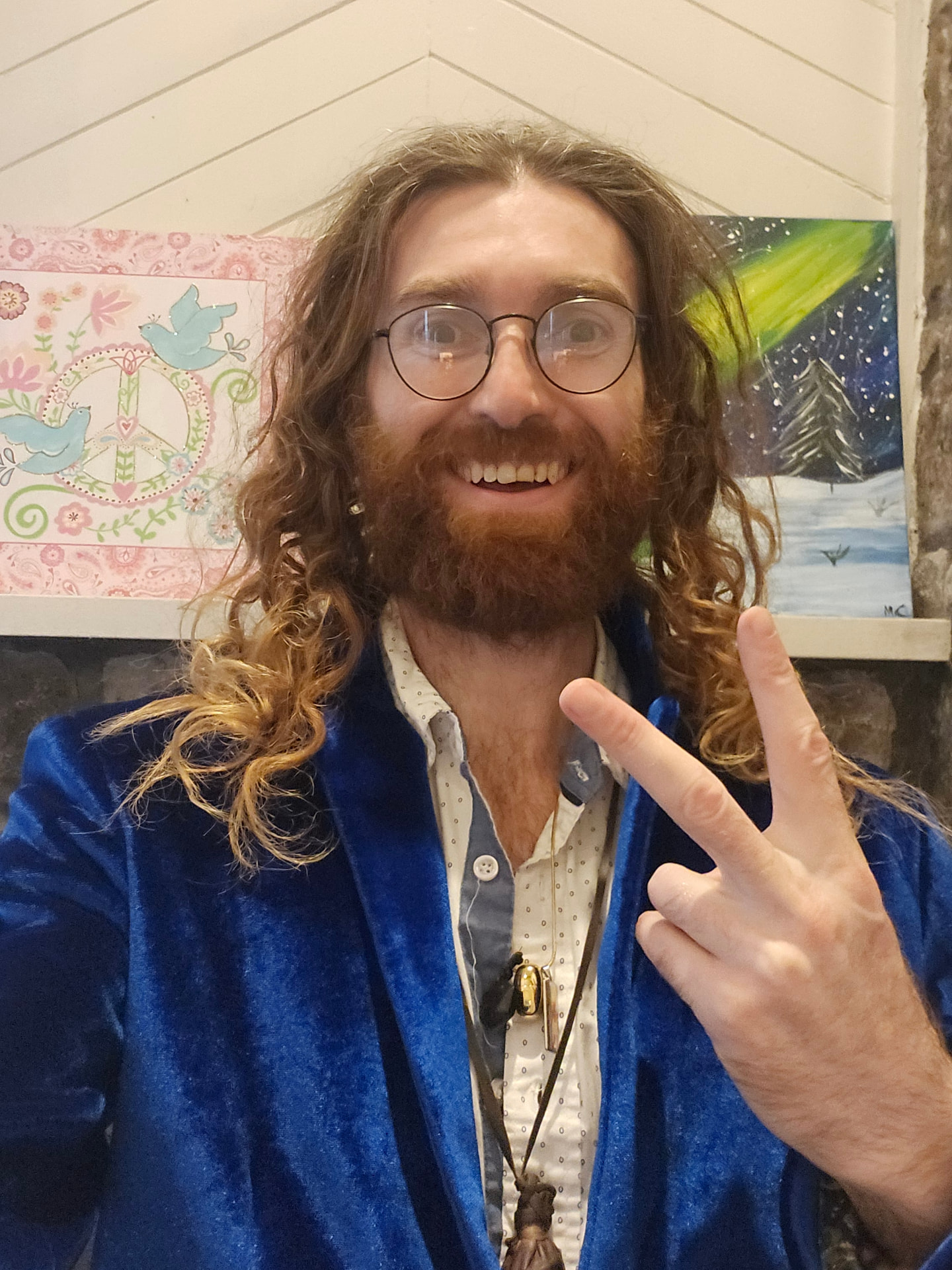 Bob before the initiation — long hair and beard, blue velvet jacket, holding up a peace sign